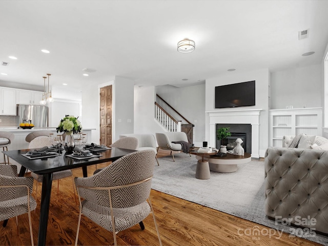 807 Herrons Ferry Rd, Rock Hill, SC 29730 - dining area with light wood finished floors, stairway, a glass covered fireplace, and recessed lighting