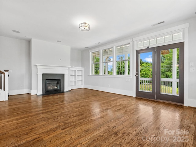 807 Herrons Ferry Rd, Rock Hill, SC 29730 - unfurnished living room with healthy amount of natural light, wood finished floors, a fireplace with flush hearth, and baseboards