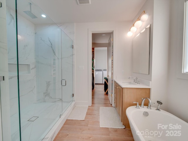 8039 Mcconnell Rd, Denver, NC 28037 - full bathroom with a marble finish shower, a freestanding tub, wood finished floors, vanity, and washer and clothes dryer