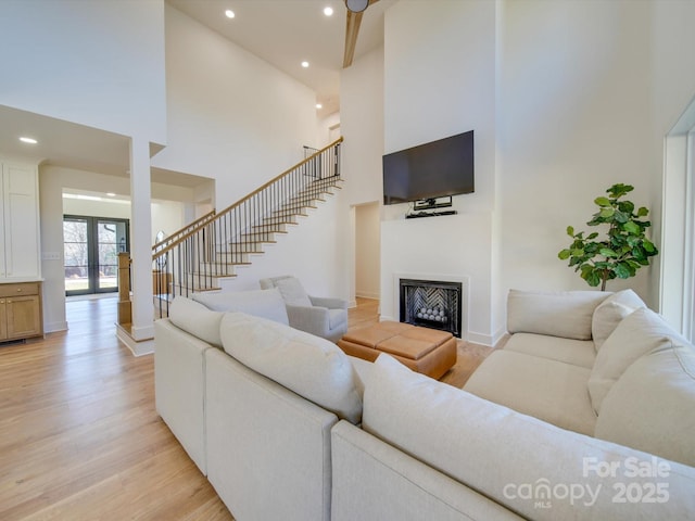 8039 Mcconnell Rd, Denver, NC 28037 - living area featuring a towering ceiling, light wood-style floors, recessed lighting, stairway, and a fireplace