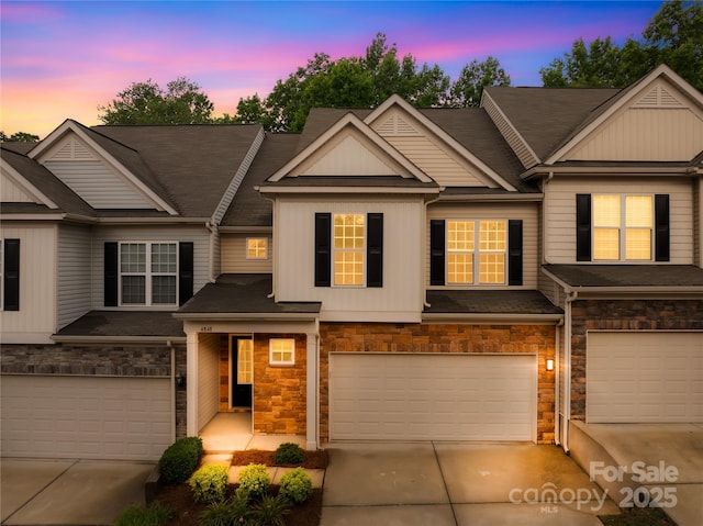 4848 Fonthill Ln, Charlotte, NC 28210 - townhome / multi-family property featuring an attached garage, driveway, stone siding, and board and batten siding