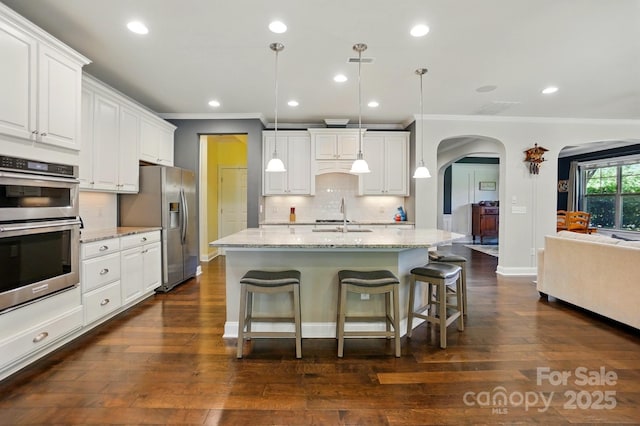 3808 Halcyon Dr, Huntersville, NC 28078 - kitchen featuring stainless steel appliances, ornamental molding, arched walkways, a sink, and backsplash