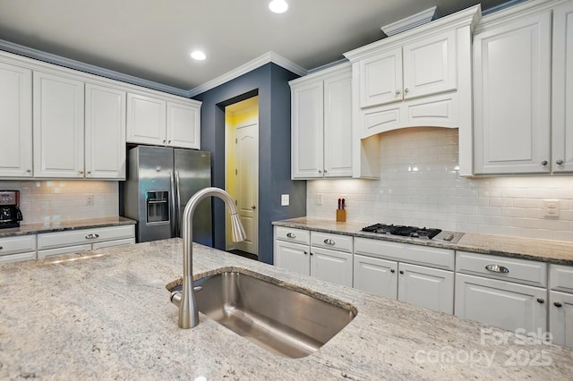 3808 Halcyon Dr, Huntersville, NC 28078 - kitchen featuring appliances with stainless steel finishes, a sink, white cabinets, crown molding, and light stone countertops