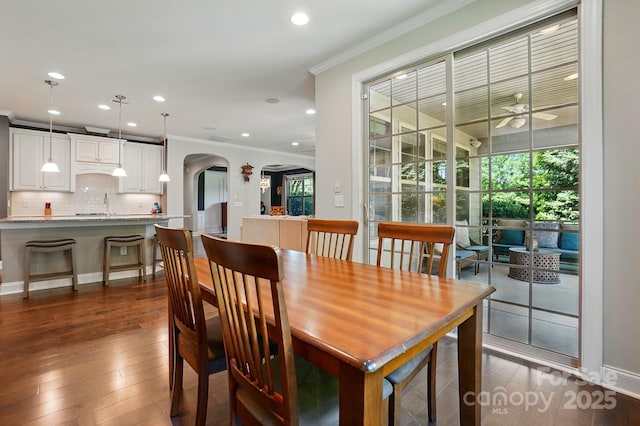 3808 Halcyon Dr, Huntersville, NC 28078 - dining area featuring crown molding, arched walkways, ceiling fan, dark wood-style floors, and recessed lighting