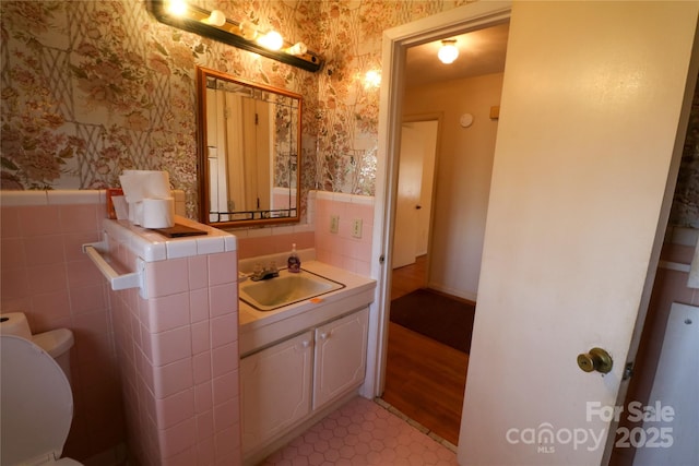 170 Heritage Ln, Salisbury, NC 28147 - half bath with wallpapered walls, a wainscoted wall, toilet, vanity, and tile walls