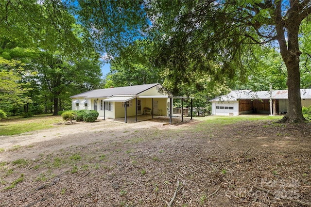 208 Lipe Rd, Troutman, NC 28166 - rear view of house with driveway, a garage, an outdoor structure, and metal roof