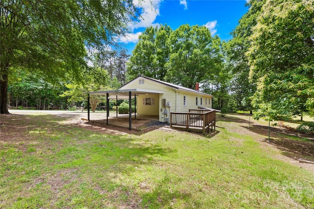 208 Lipe Rd, Troutman, NC 28166 - rear view of property featuring a lawn, a deck, a chimney, and view of wooded area