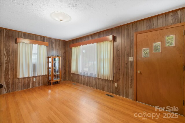 208 Lipe Rd, Troutman, NC 28166 - entrance foyer featuring wood walls, wood finished floors, and a textured ceiling