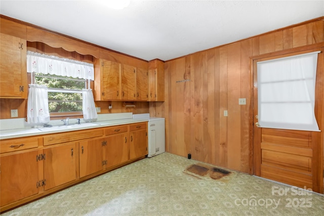 208 Lipe Rd, Troutman, NC 28166 - kitchen featuring light countertops, brown cabinetry, wooden walls, and light floors