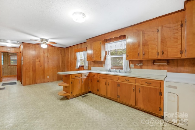 208 Lipe Rd, Troutman, NC 28166 - kitchen featuring washer / clothes dryer, ceiling fan, brown cabinetry, light countertops, and light flooring