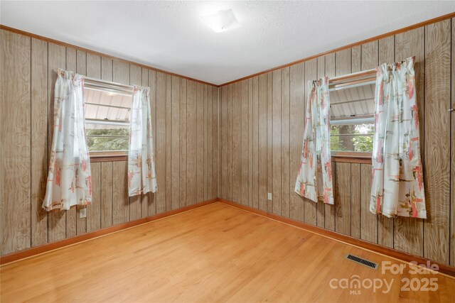 208 Lipe Rd, Troutman, NC 28166 - unfurnished room featuring wood finished floors, plenty of natural light, baseboards, and wooden walls