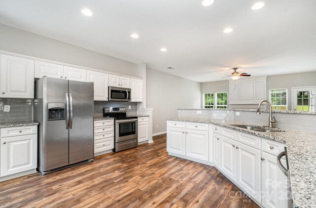 6922 Cascade Dream Ct, Huntersville, NC 28078 - kitchen with stainless steel appliances, a sink, backsplash, ceiling fan, and wood finished floors