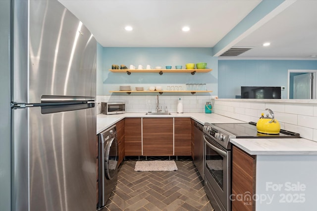 194 Mark Twain Dr, Lake Lure, NC 28743 - kitchen with stainless steel appliances, brown cabinetry, a sink, tasteful backsplash, and recessed lighting