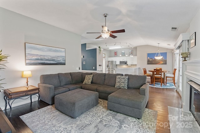 1310 Bellhook Pl NW, Concord, NC 28027 - living room with wood finished floors, a ceiling fan, lofted ceiling, baseboards, and rail lighting