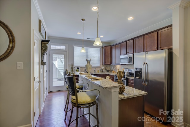1225 Assembly St, Belmont, NC 28012 - kitchen with stainless steel appliances, ornamental molding, a breakfast bar area, light stone countertops, and pendant lighting