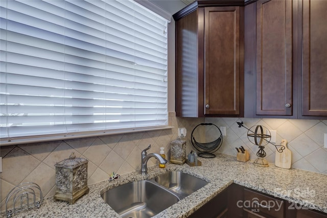 1225 Assembly St, Belmont, NC 28012 - kitchen with a sink, dark brown cabinetry, backsplash, and light stone countertops