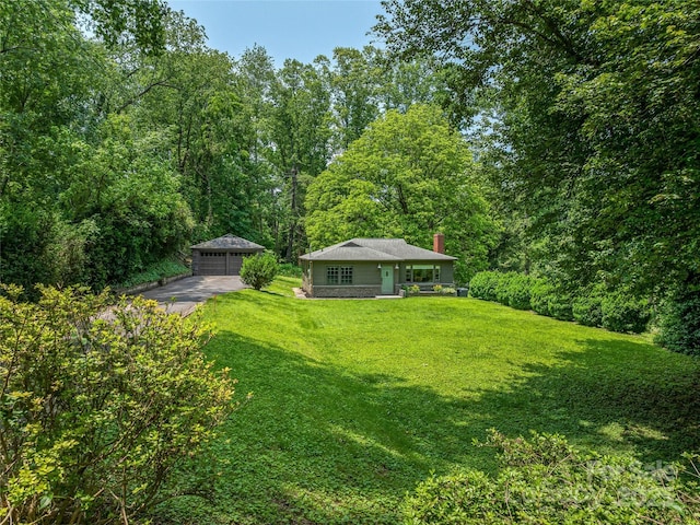 90 W Skyland Cir Unit 1, Asheville, NC 28804 - view of green lawn featuring a detached garage, an outbuilding, and a wooded view