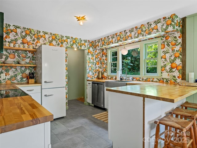 90 W Skyland Cir Unit 1, Asheville, NC 28804 - kitchen featuring wallpapered walls, butcher block counters, dishwasher, white cabinetry, and a kitchen breakfast bar