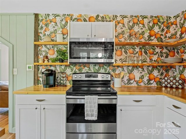 90 W Skyland Cir Unit 1, Asheville, NC 28804 - kitchen with stainless steel appliances, white cabinets, open shelves, butcher block counters, and wallpapered walls