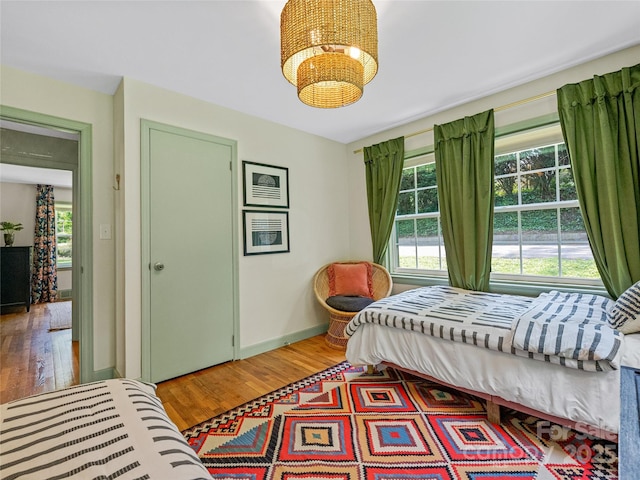 90 W Skyland Cir Unit 1, Asheville, NC 28804 - bedroom with light wood-style flooring, a chandelier, and baseboards