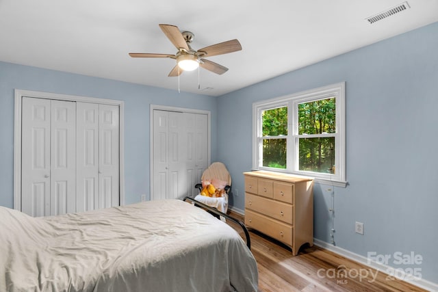 5317 Black Oak Ln Unit 11, Waxhaw, NC 28173 - bedroom featuring two closets, baseboards, light wood-style flooring, and a ceiling fan