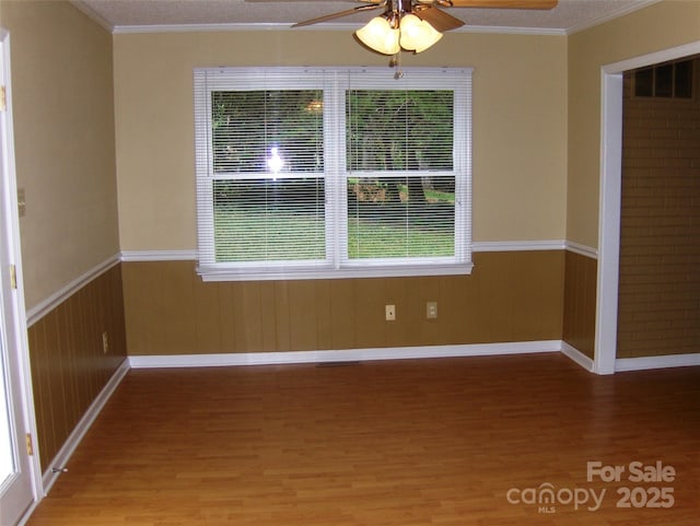 134 Crystal Cir, Mooresville, NC 28117 - spare room featuring ceiling fan, wood finished floors, crown molding, baseboards, and wainscoting