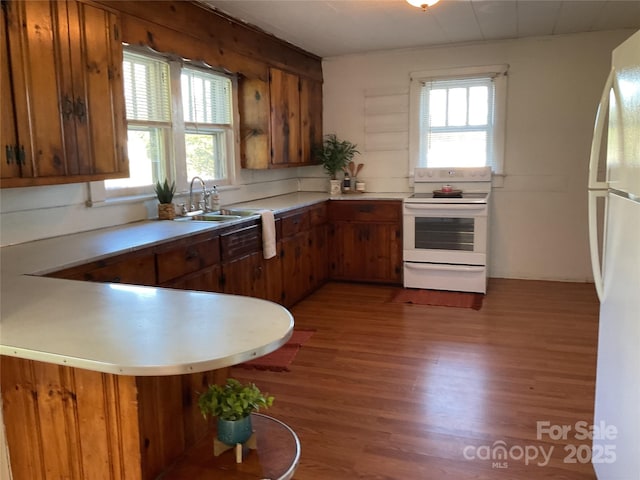 2138 SW Haven Cir, Lenoir, NC 28645 - kitchen featuring white appliances, brown cabinets, light countertops, a sink, and wood finished floors