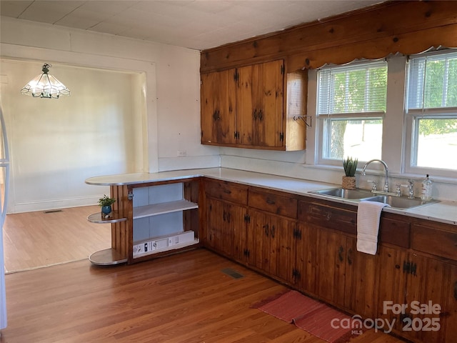 2138 SW Haven Cir, Lenoir, NC 28645 - kitchen featuring a sink, light wood finished floors, light countertops, and plenty of natural light