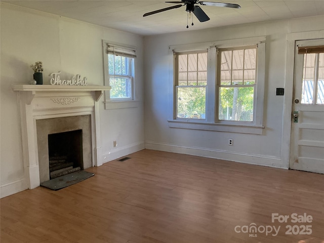2138 SW Haven Cir, Lenoir, NC 28645 - unfurnished living room with ceiling fan, wood finished floors, baseboards, and a fireplace