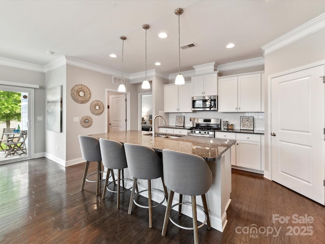 505 Belle Grove Dr, Lake Wylie, SC 29710 - kitchen with stainless steel appliances, a sink, a breakfast bar area, a center island with sink, and backsplash