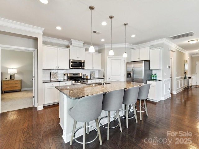 505 Belle Grove Dr, Lake Wylie, SC 29710 - kitchen featuring appliances with stainless steel finishes, a breakfast bar area, crown molding, white cabinetry, and dark wood finished floors