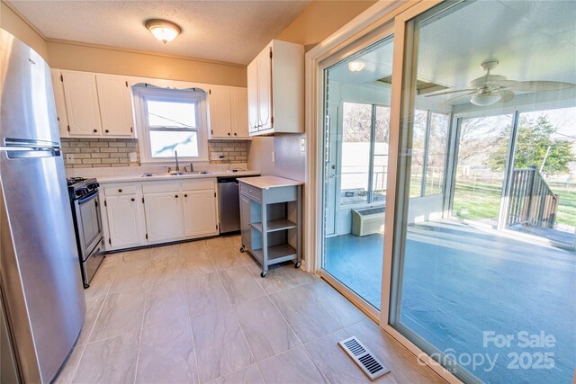15 Oak Leaf Ln, Arden, NC 28704 - kitchen featuring appliances with stainless steel finishes, a sink, white cabinetry, light countertops, and tasteful backsplash