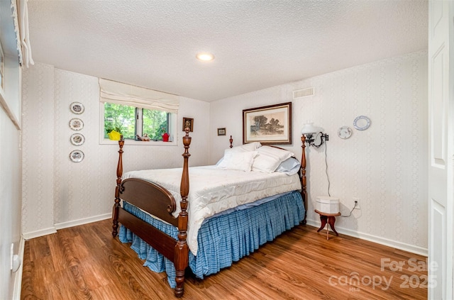 1102 Lake Montonia Rd, Kings Mountain, NC 28086 - bedroom featuring wood finished floors, wallpapered walls, and a textured ceiling
