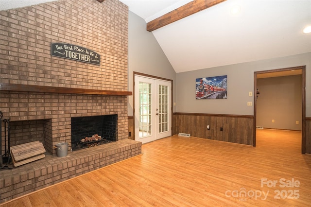 1565 Earnhardt Rd, Salisbury, NC 28146 - unfurnished living room with beamed ceiling, wood finished floors, wainscoting, a fireplace, and french doors
