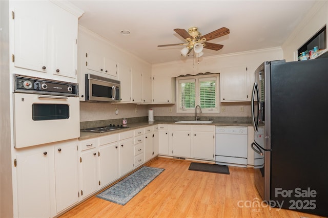 1565 Earnhardt Rd, Salisbury, NC 28146 - kitchen with stainless steel appliances, a sink, a ceiling fan, white cabinetry, and light wood-type flooring