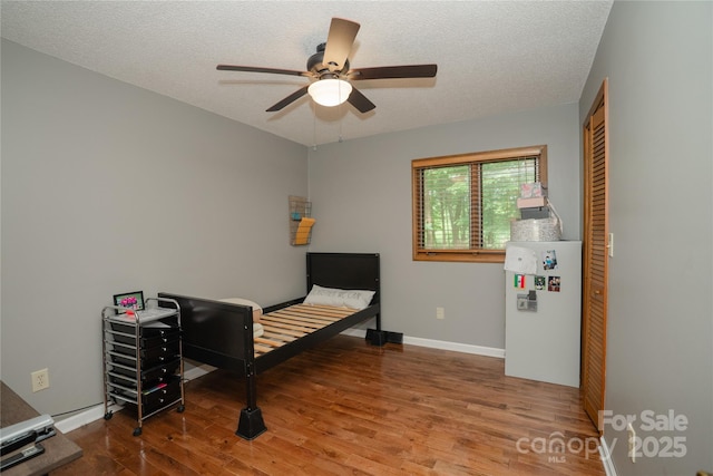 1565 Earnhardt Rd, Salisbury, NC 28146 - bedroom featuring wood finished floors, a textured ceiling, baseboards, a ceiling fan, and a closet