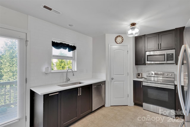117 Langhorne Dr, Mount Holly, NC 28120 - kitchen featuring appliances with stainless steel finishes, a sink, decorative backsplash, and light countertops