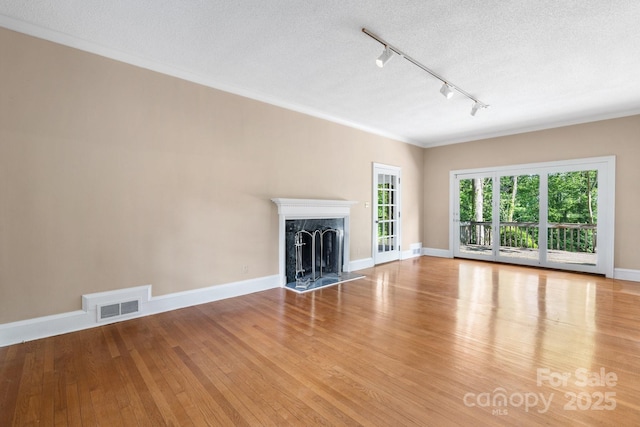 220 W Park Dr, Morganton, NC 28655 - unfurnished living room featuring rail lighting, wood finished floors, baseboards, a premium fireplace, and ornamental molding