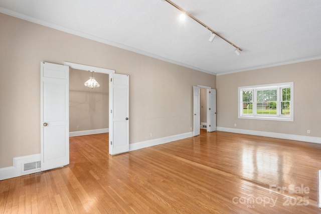 220 W Park Dr, Morganton, NC 28655 - spare room featuring ornamental molding, light wood finished floors, rail lighting, a chandelier, and baseboards