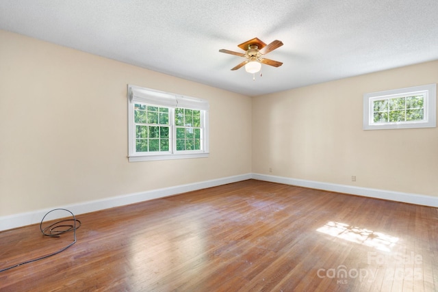 220 W Park Dr, Morganton, NC 28655 - empty room featuring plenty of natural light, wood finished floors, baseboards, a ceiling fan, and a textured ceiling