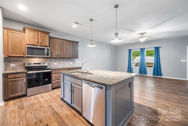 3053 Riker St, Clover, SC 29710 - kitchen with appliances with stainless steel finishes, a sink, decorative backsplash, light stone countertops, and light wood-style flooring