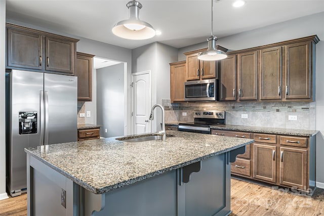 3053 Riker St, Clover, SC 29710 - kitchen with appliances with stainless steel finishes, a sink, stone counters, light wood finished floors, and decorative backsplash