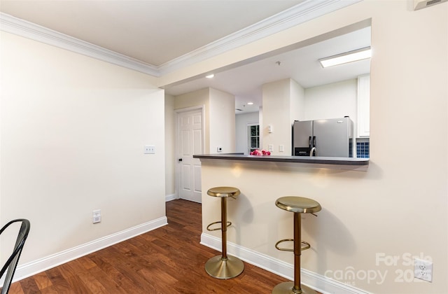 1136 W 1st St, Charlotte, NC 28202 - kitchen with stainless steel refrigerator with ice dispenser, a kitchen breakfast bar, crown molding, baseboards, and dark wood-type flooring