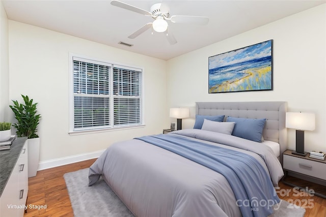 1136 W 1st St, Charlotte, NC 28202 - bedroom with wood finished floors, baseboards, and a ceiling fan