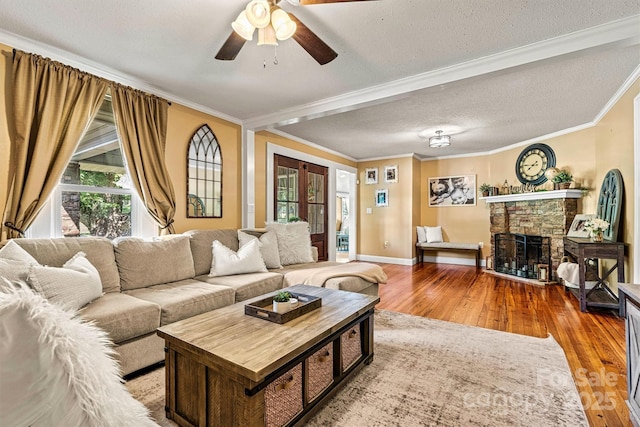 454 N Eastway Dr, Troutman, NC 28166 - living room featuring hardwood / wood-style flooring, ceiling fan, baseboards, a stone fireplace, and crown molding