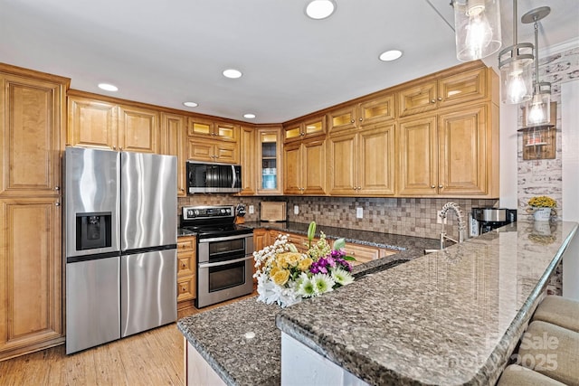 454 N Eastway Dr, Troutman, NC 28166 - kitchen with appliances with stainless steel finishes, a peninsula, dark stone countertops, a kitchen bar, and backsplash