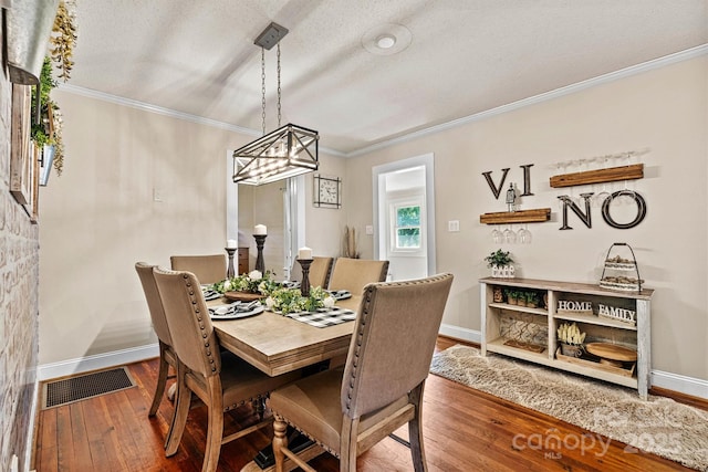 454 N Eastway Dr, Troutman, NC 28166 - dining room featuring baseboards, ornamental molding, hardwood / wood-style flooring, a chandelier, and a textured ceiling