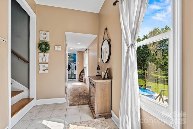 454 N Eastway Dr, Troutman, NC 28166 - hall with healthy amount of natural light, stairway, light tile patterned floors, and baseboards