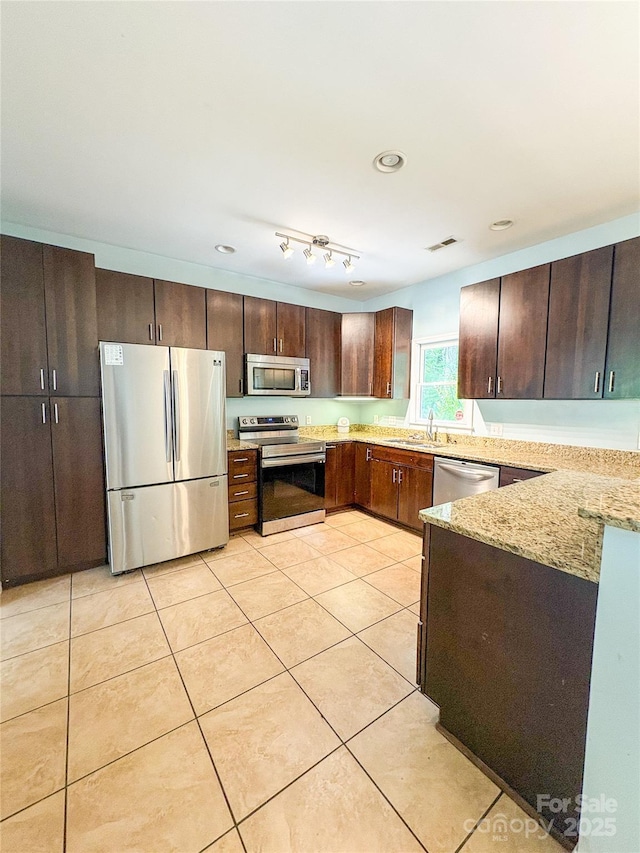 3430 Fincher Blvd, Charlotte, NC 28269 - kitchen featuring stainless steel appliances, light stone counters, light tile patterned floors, dark brown cabinets, and a sink