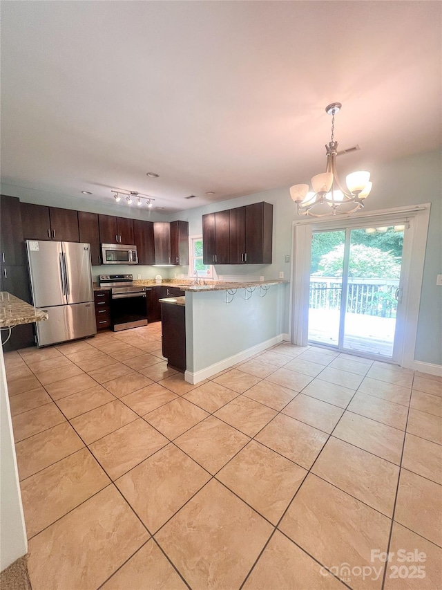 3430 Fincher Blvd, Charlotte, NC 28269 - kitchen featuring stainless steel appliances, a chandelier, light tile patterned floors, and dark brown cabinets